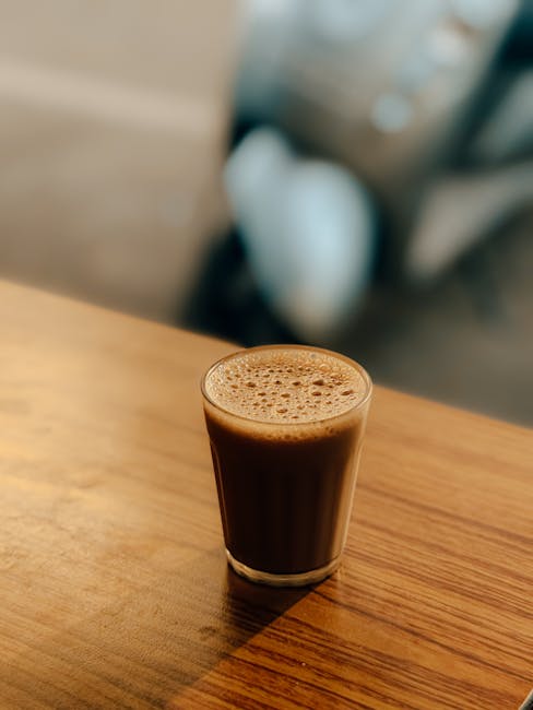 A glass of authentic Indian chai on a wooden table